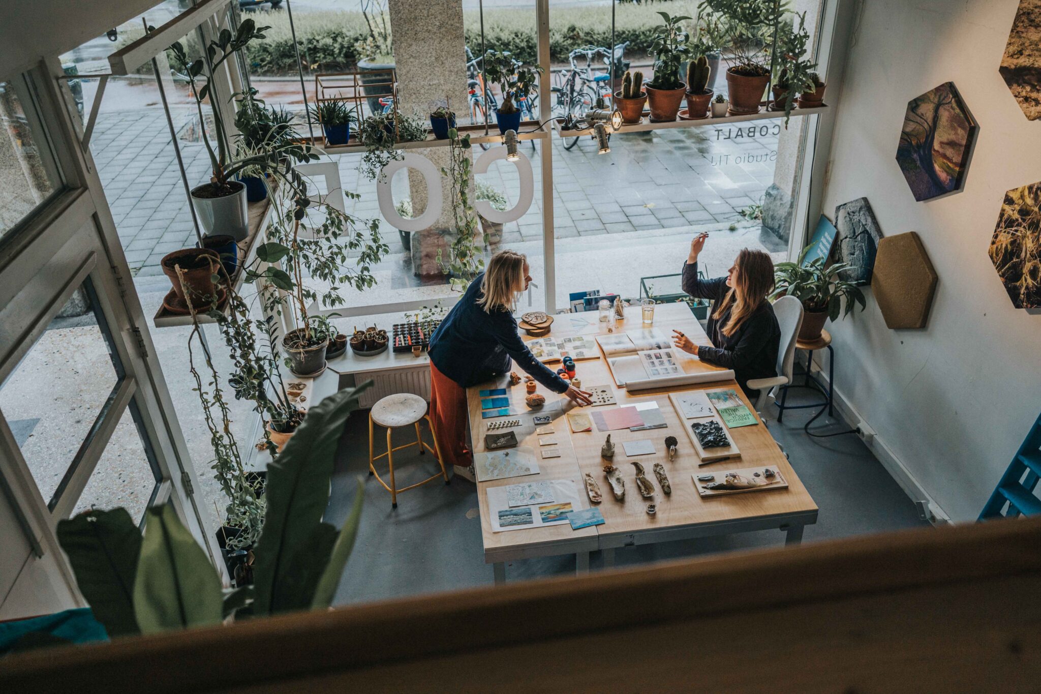 Studio Tij en Cobalt werkend aan tafel bij een raam